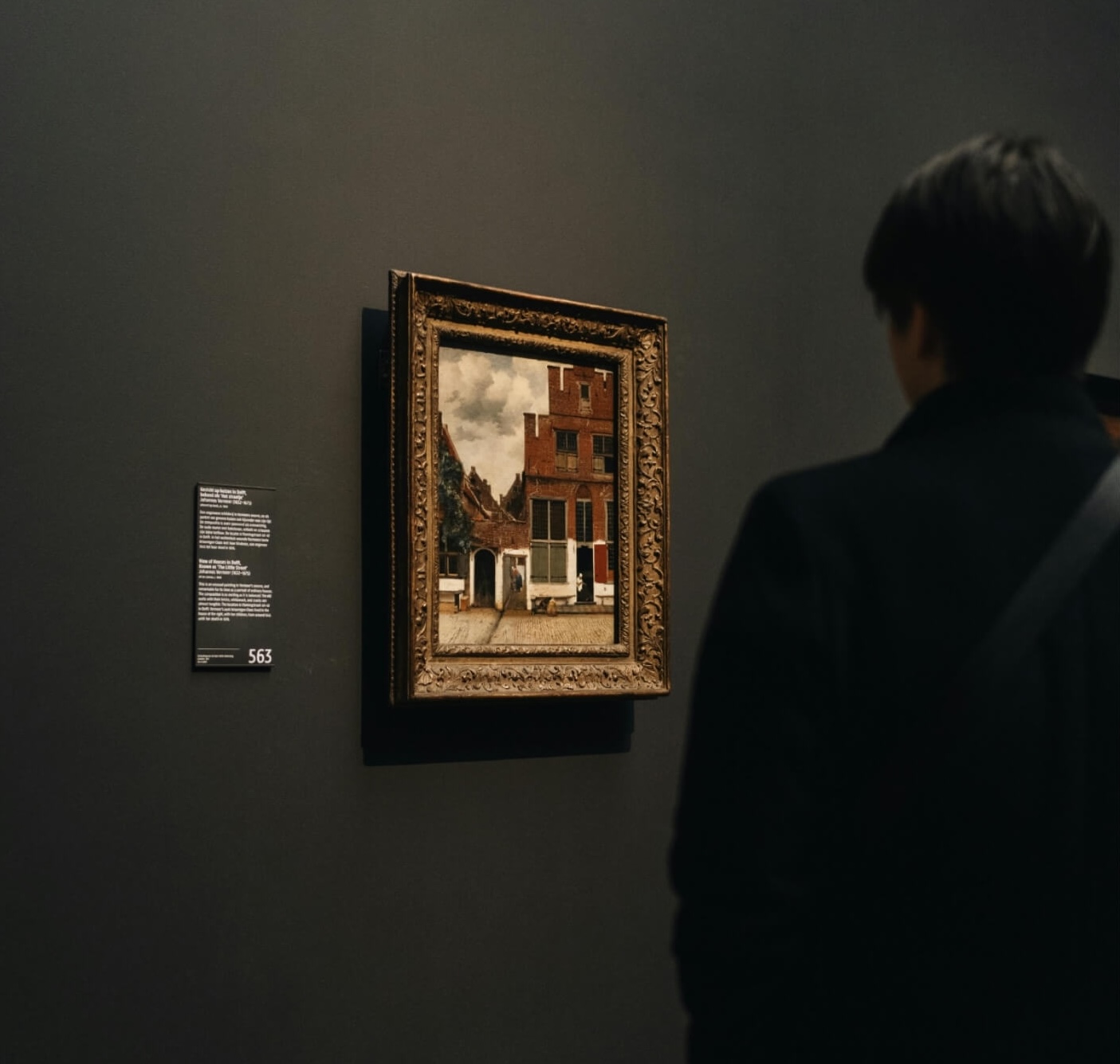 visitor at museum viewing a small painting