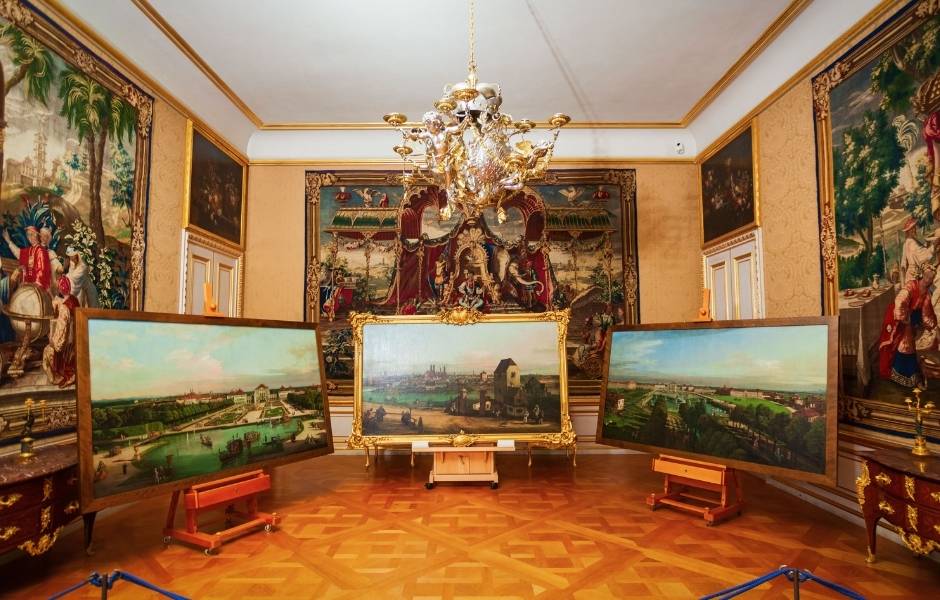 Paintings and tapestries in an ornate gallery representing collections conservation teams document in TMS Conservation Studio.