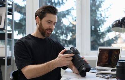 Photographer reviewing captured images at a desk, supporting efficient media import and ingest workflows in TMS Media Studio