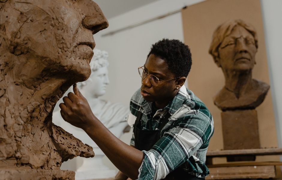 Sculptor working on a clay bust, representing the collection care conservation teams document in TMS Conservation Studio.