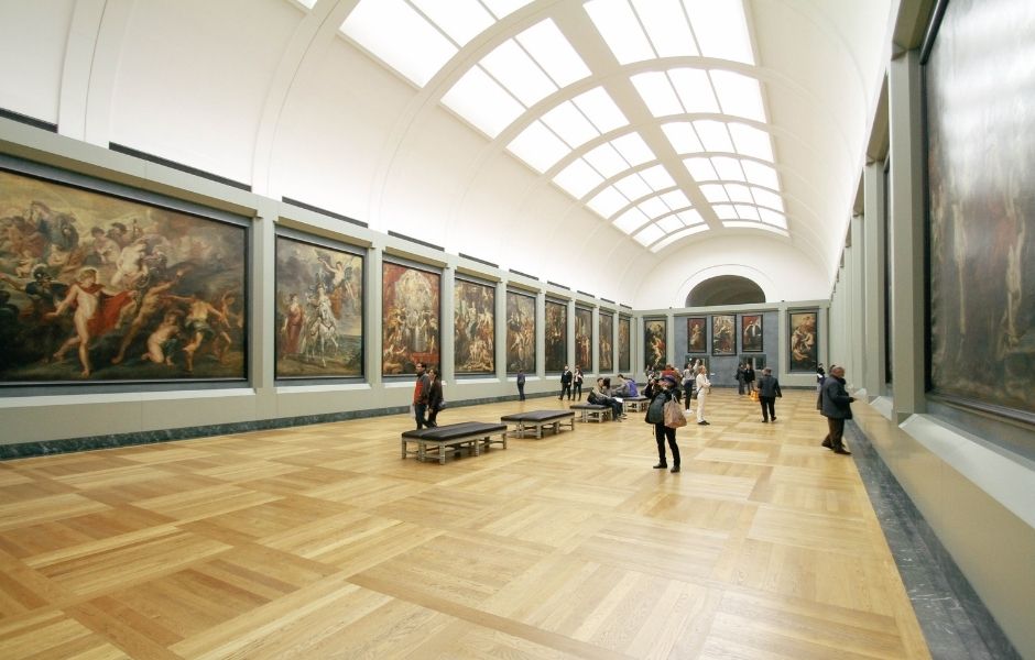 Grand gallery hall lined with large paintings representing the collections cultural institutions manage with Gallery Systems