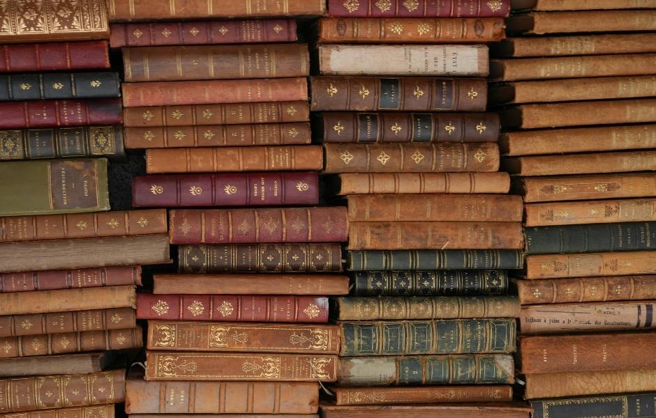 A dense arrangement of antique leather-bound books with gilt spines, reflecting the breadth of archival holdings