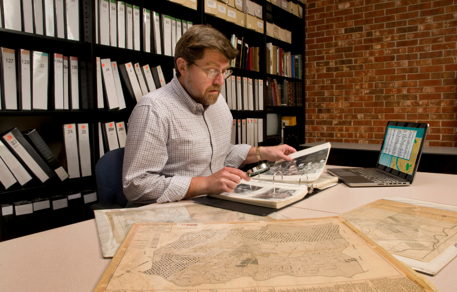 museum archivist staff member working on documents
