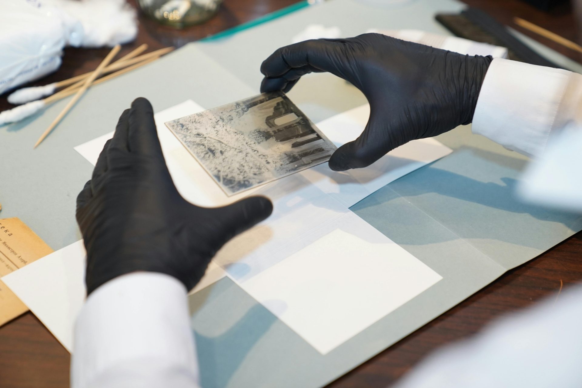 museum archivist cleaning an artwork.