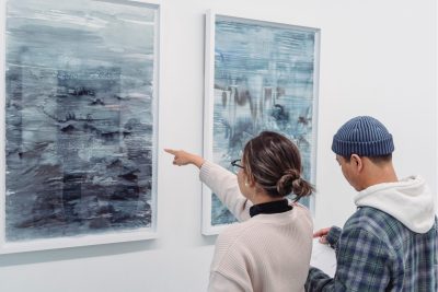 art collector pointing at an artwork they are interested in.