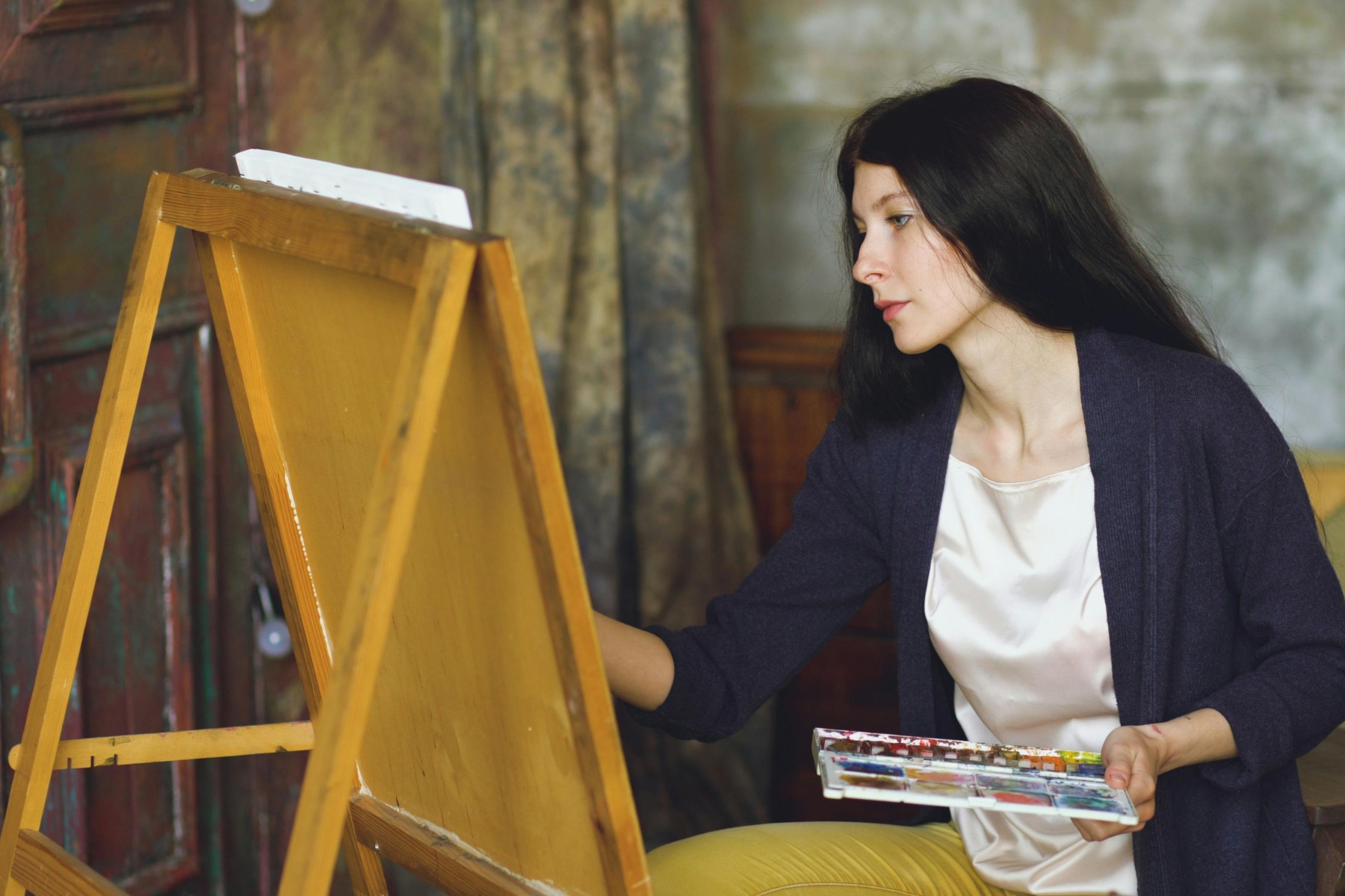 artist working in her studio at an easel