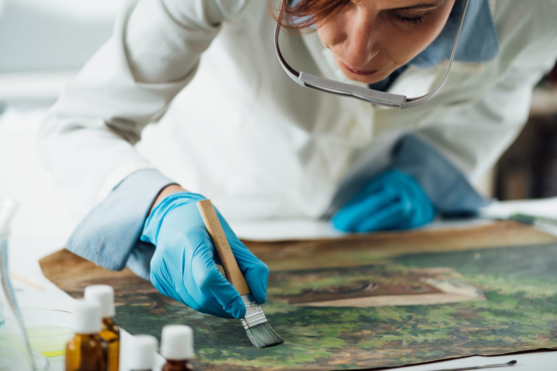 museum archivist restoring painting from the collection.