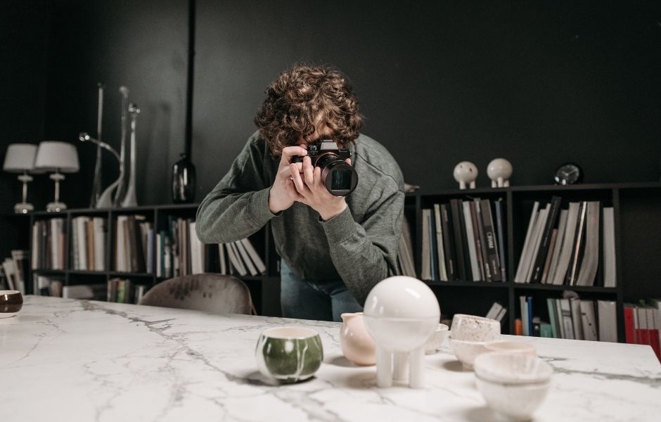 Collections staff photographing ceramic objects arranged on a surface, documenting digital assets for long-term preservation