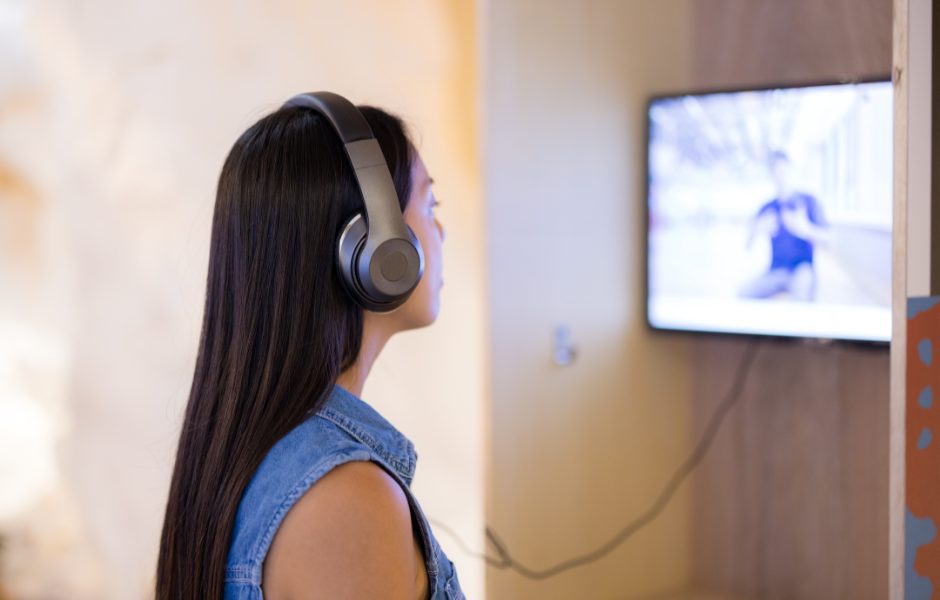 visitor of a museum using headphones for a video piece