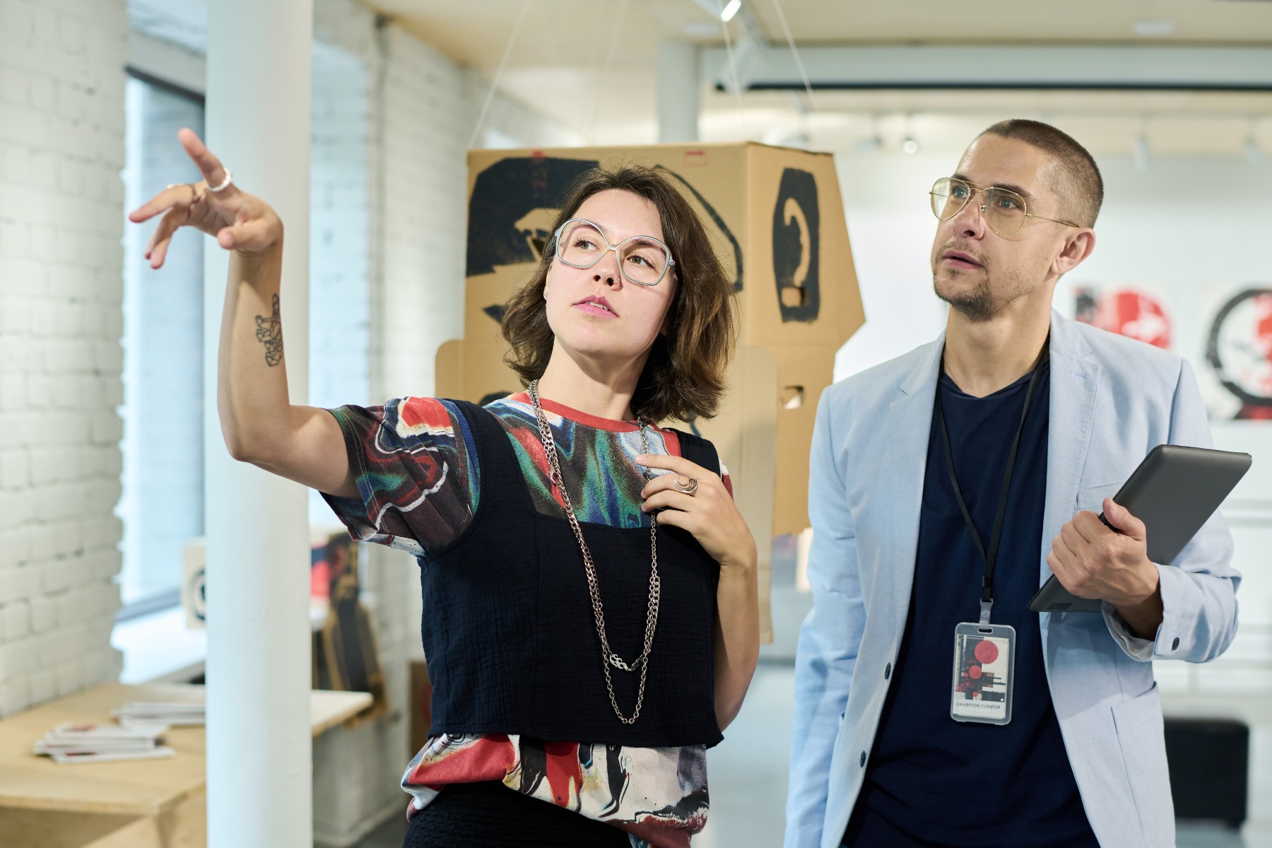 gallerist pointing out next task during an art exhibition install.