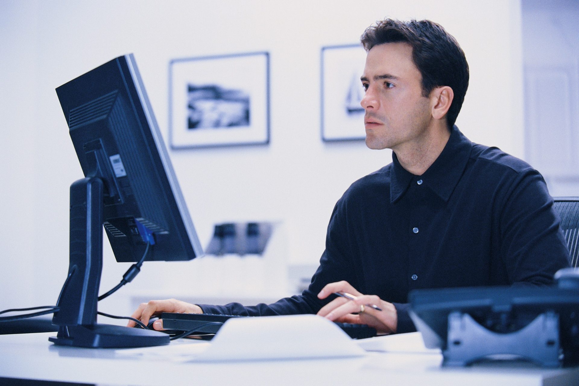 gallery director working at the computer updating the gallery's website.
