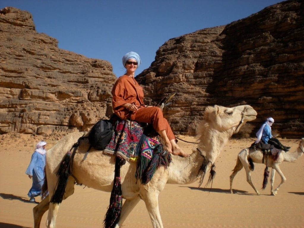 Judith riding a camel in the south of Algeria