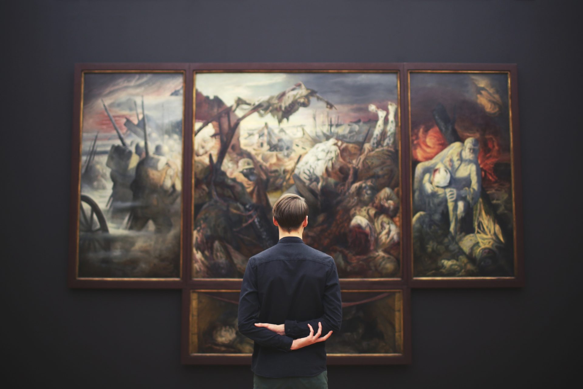 museum curator reviewing the installation of a large 4 piece painting.