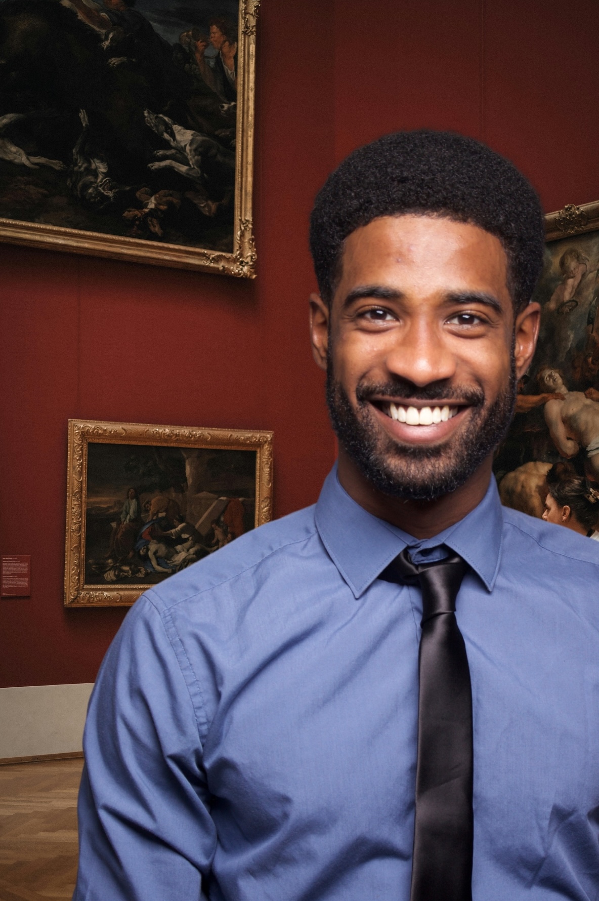 museum curator posing in an exhibition room.