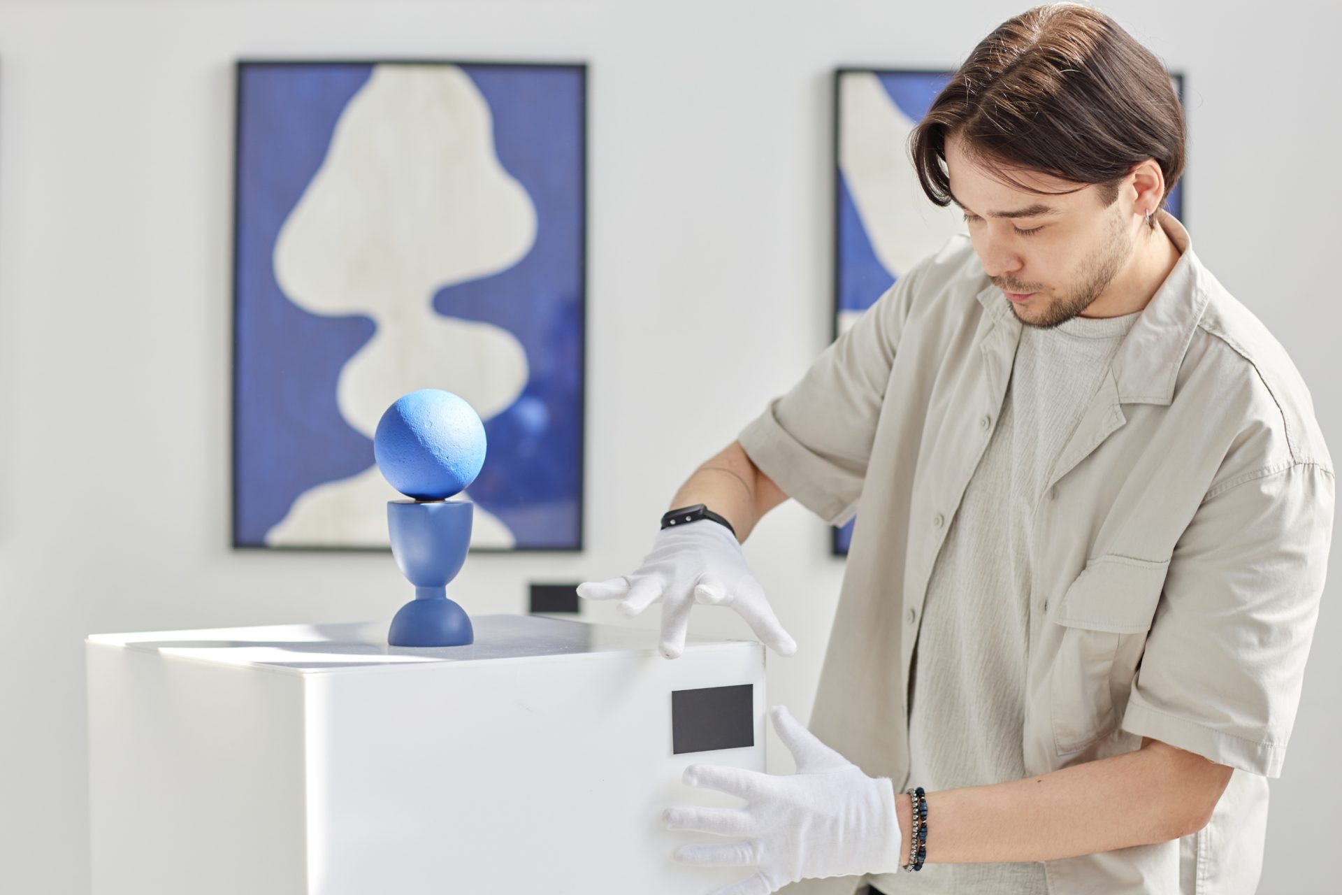 museum staff member working on installing artwork in exhibition.