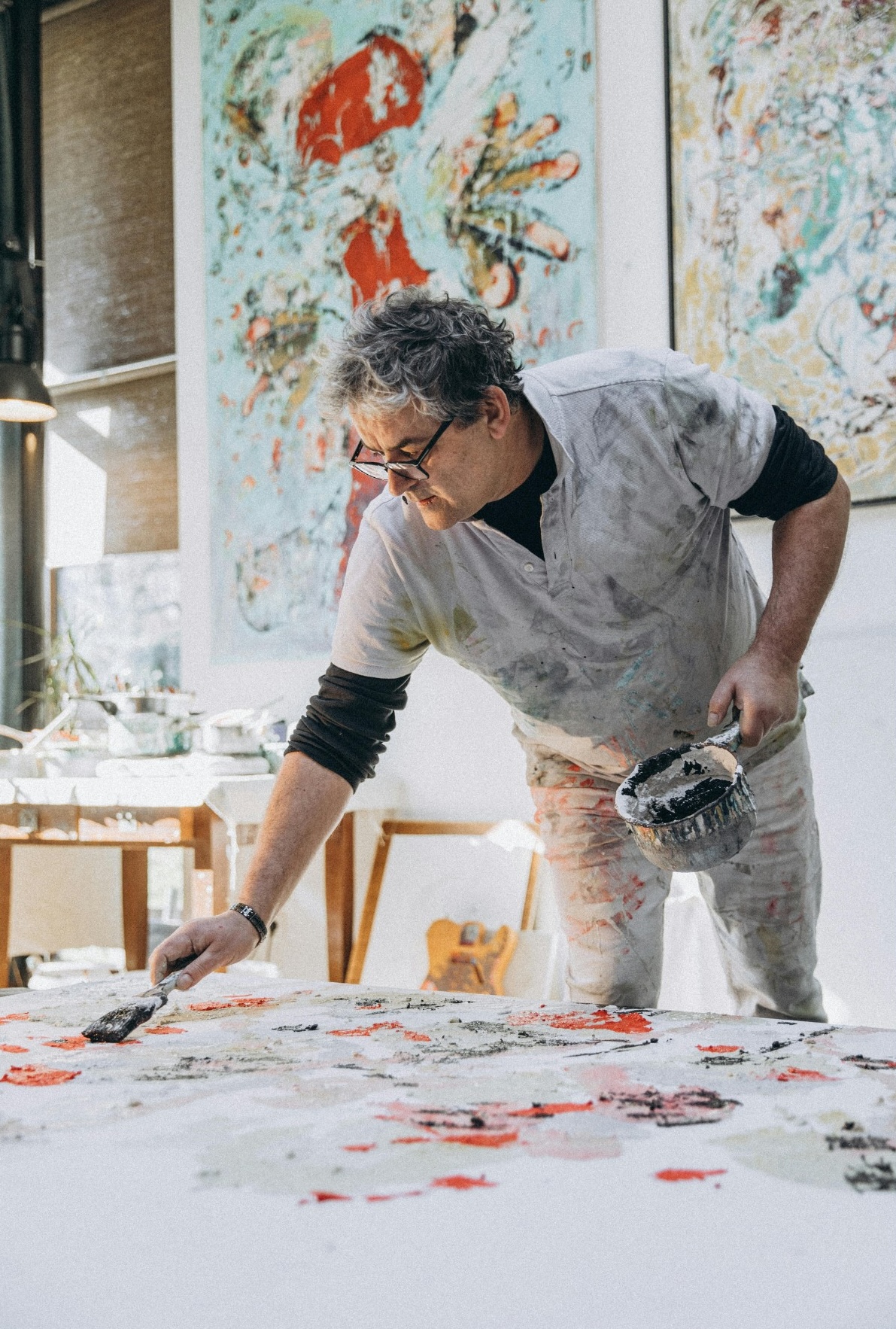 older painter working on a large scale painting.