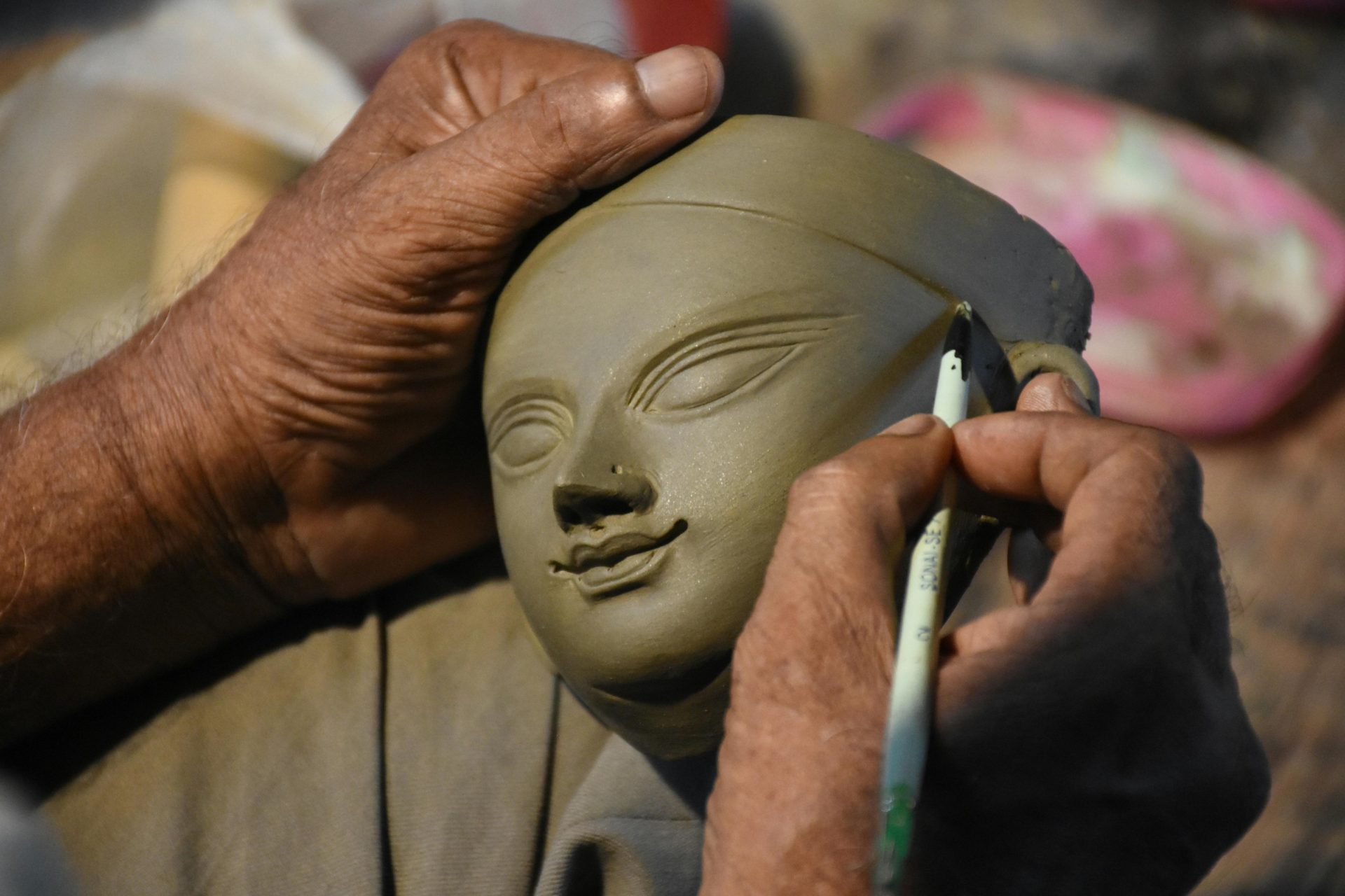 sculptor working on the details of a face in clay.