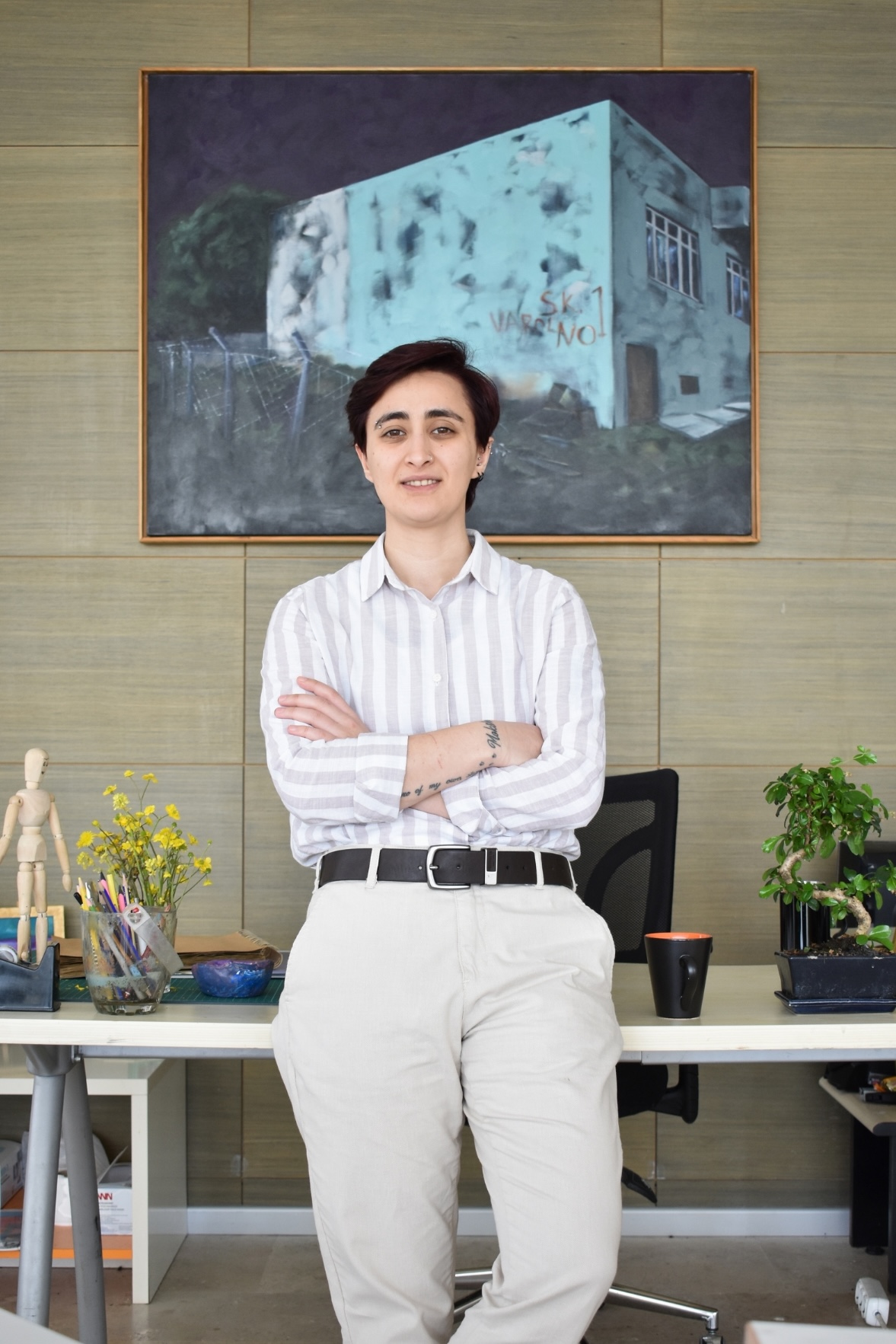 university dean posing in their office with a desk and painting behind them.