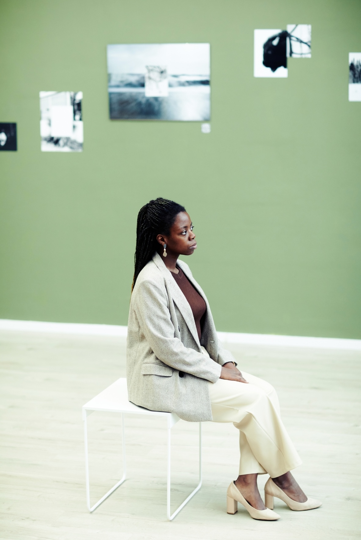 museum visitor sitting in an exhibition space viewing art.