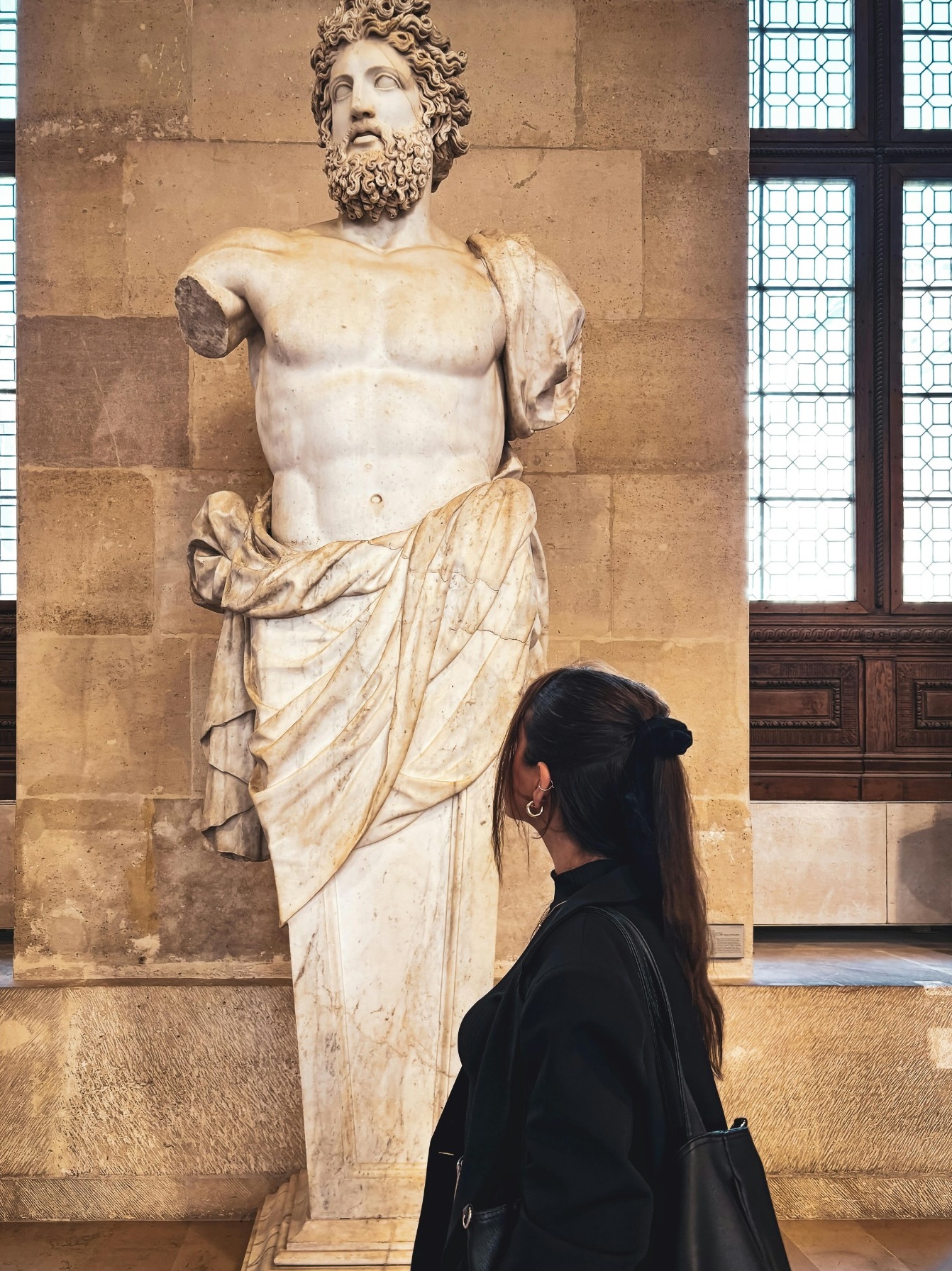 woman looking at an ancient statue.