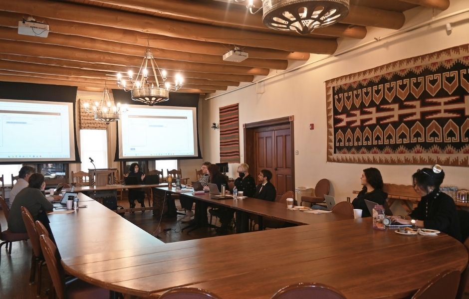 Collections staff attending a training session in a characterful conference room with projected software screens and woven textiles on the walls