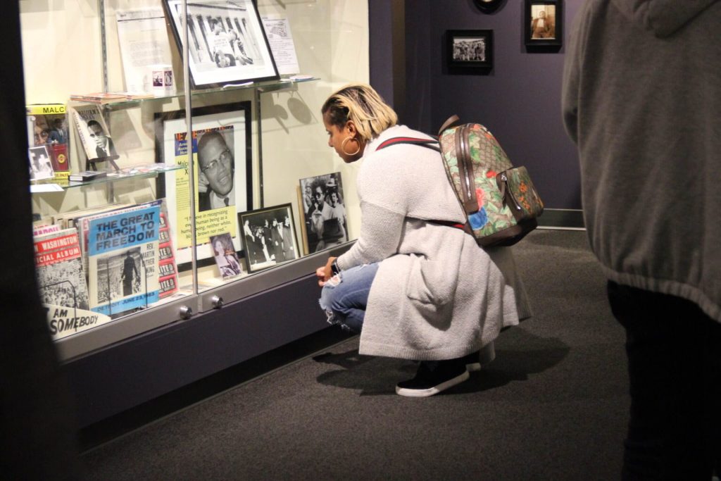 Visitor viewing a display case inside the Jim Crow Museum
