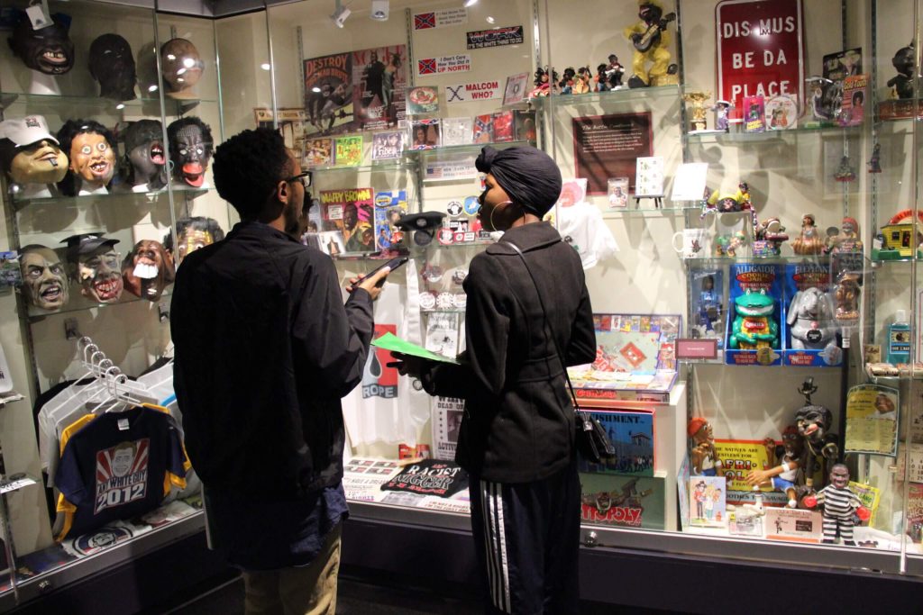 Visitors viewing a display case inside the Jim Crow Museum