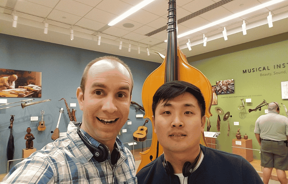 Pausing beside a musical instrument display during a museum visit.
